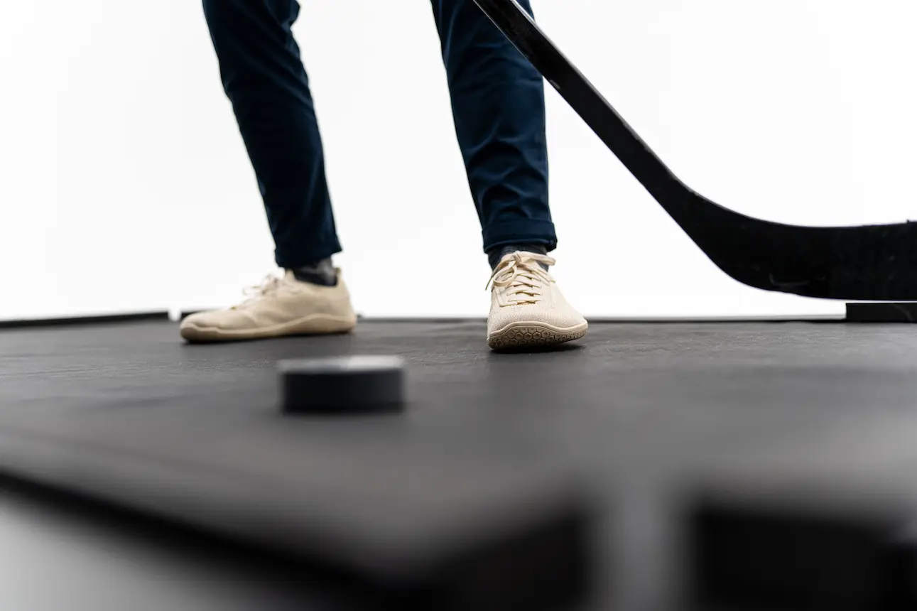 Feet, stick, and puck on the Danglemat surface